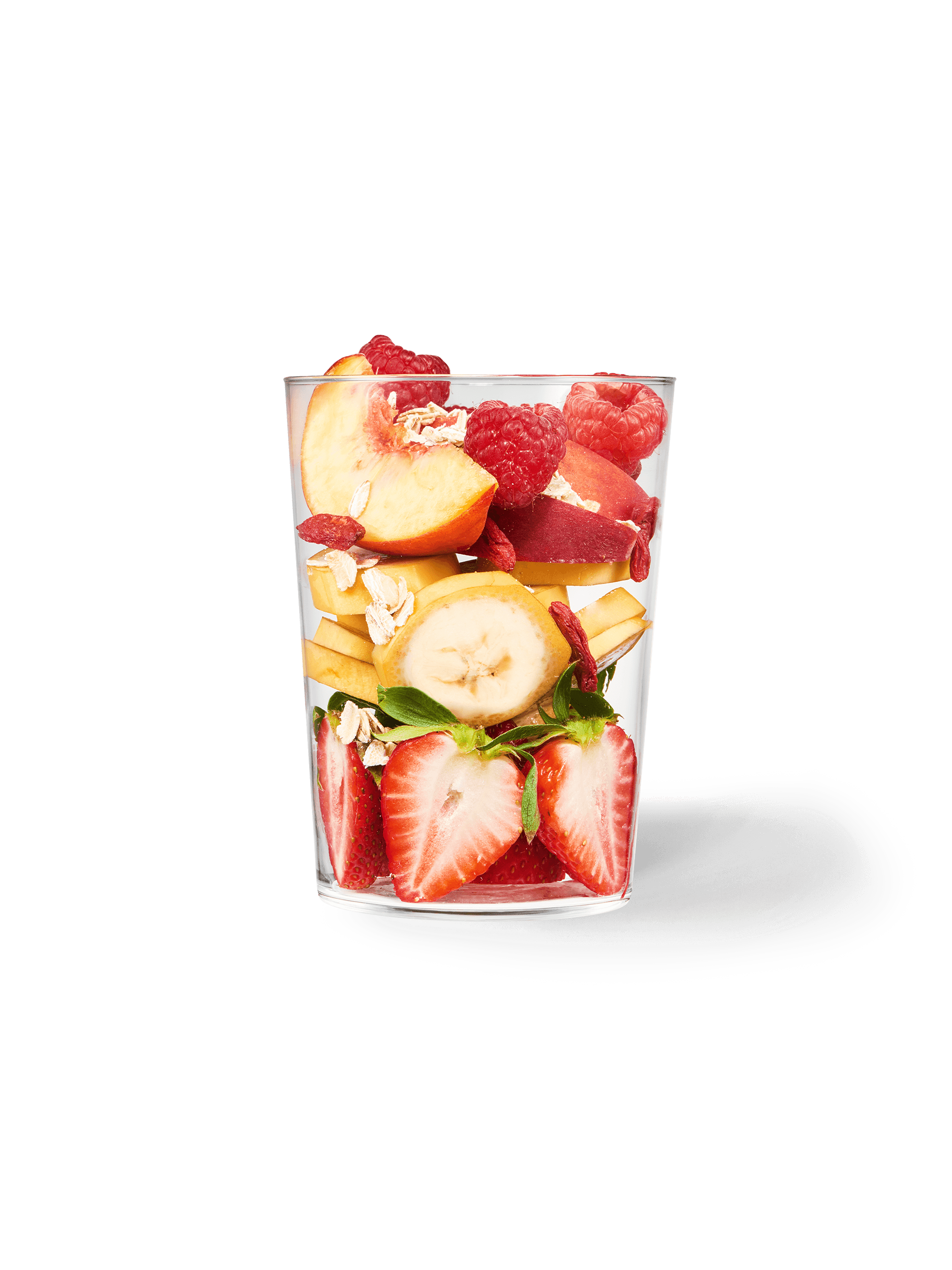 Clear cup filled with the ingredients included in our Daily Harvest Strawberry + Peach Smoothie.