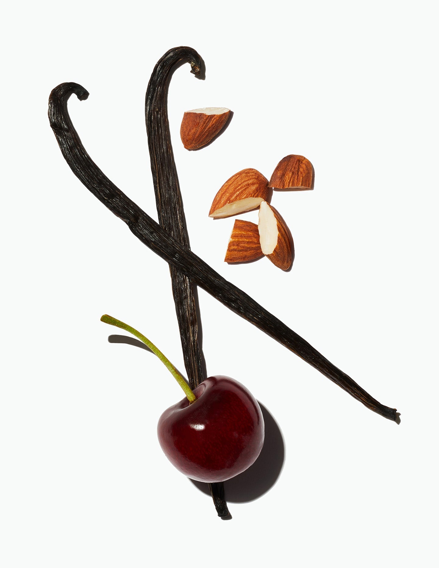 A cherry alongside whole vanilla beans and almond pieces