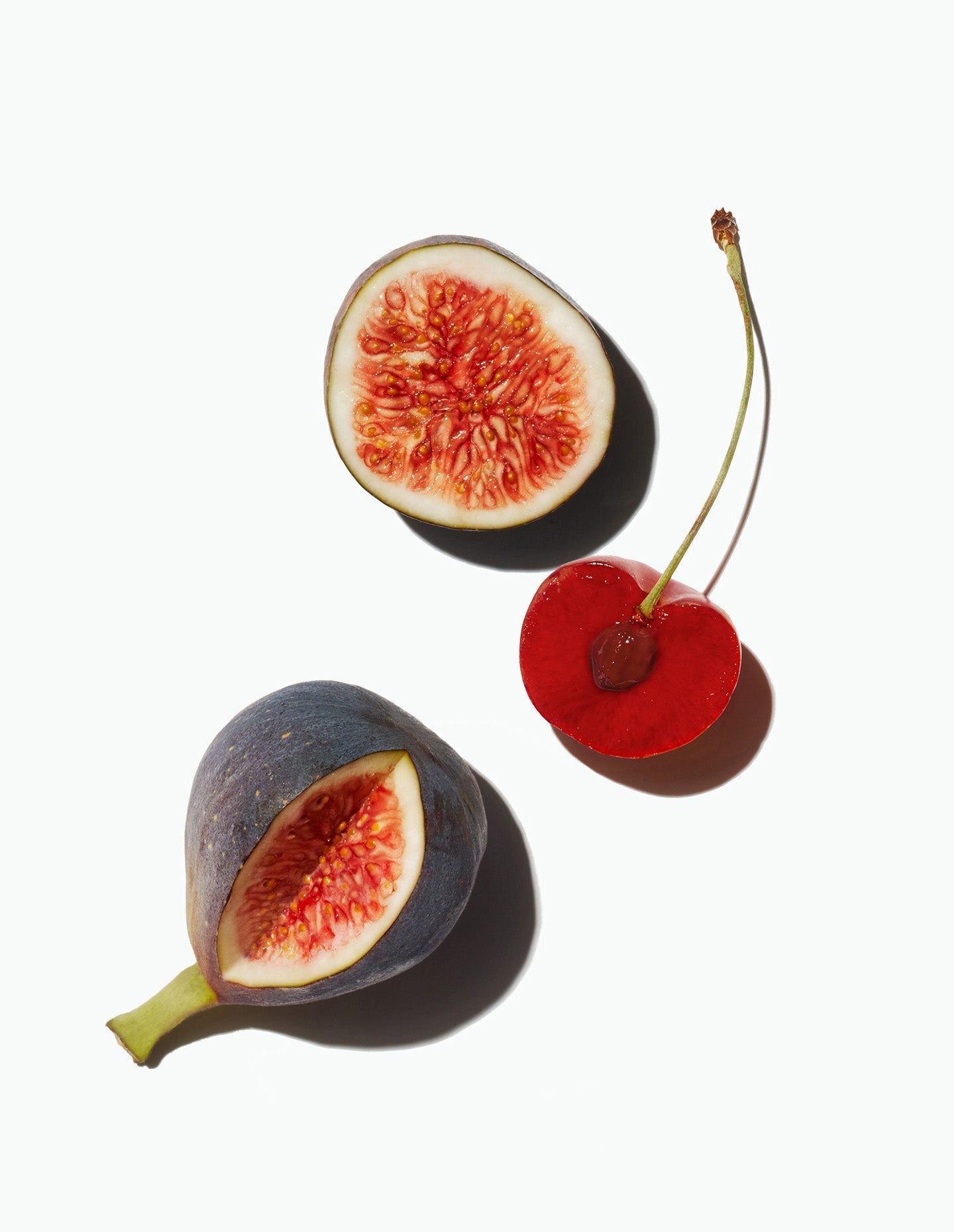 A halved cherry alongside a sliced fig