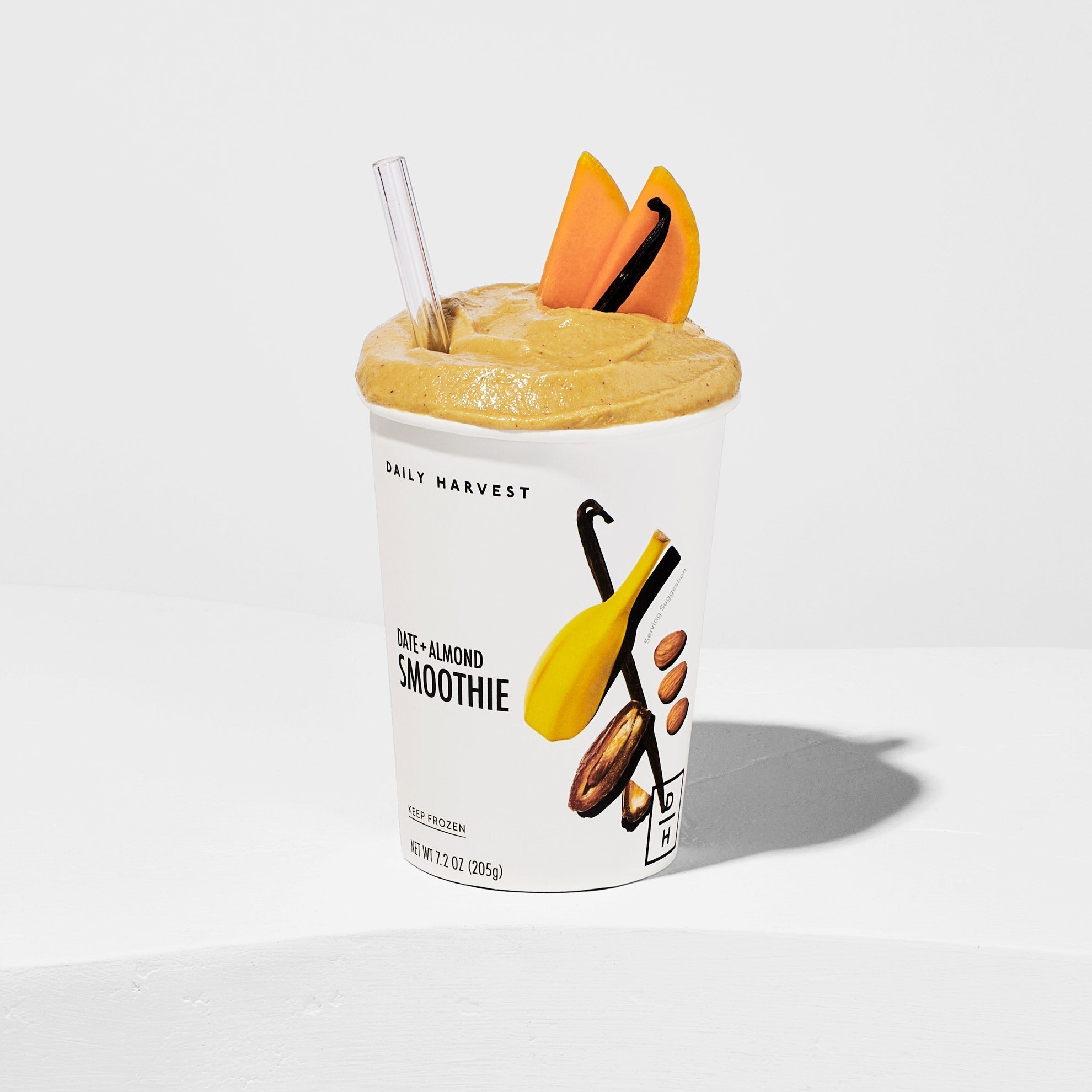 a prepared date and almond smoothie with a garnish of two slices of butternut squash and a vanilla bean 