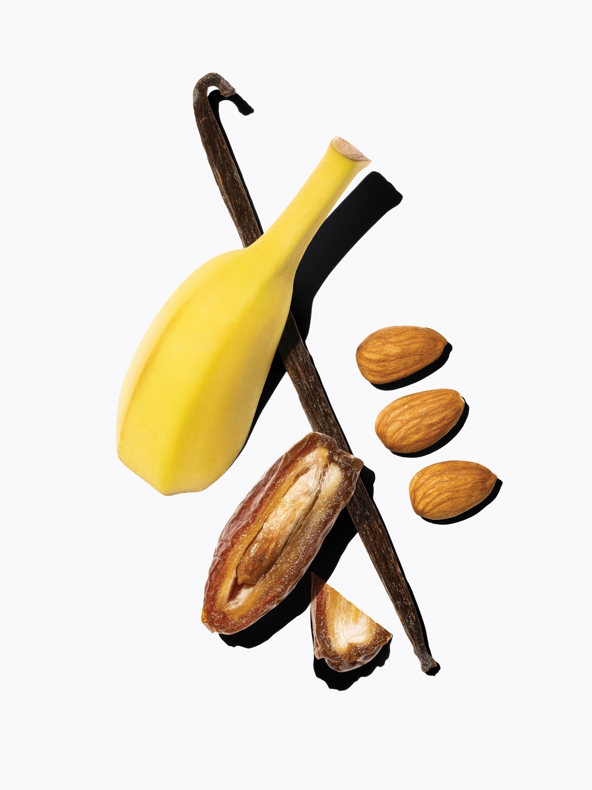 a halved banana, vanilla bean pod, halved date, and three almonds