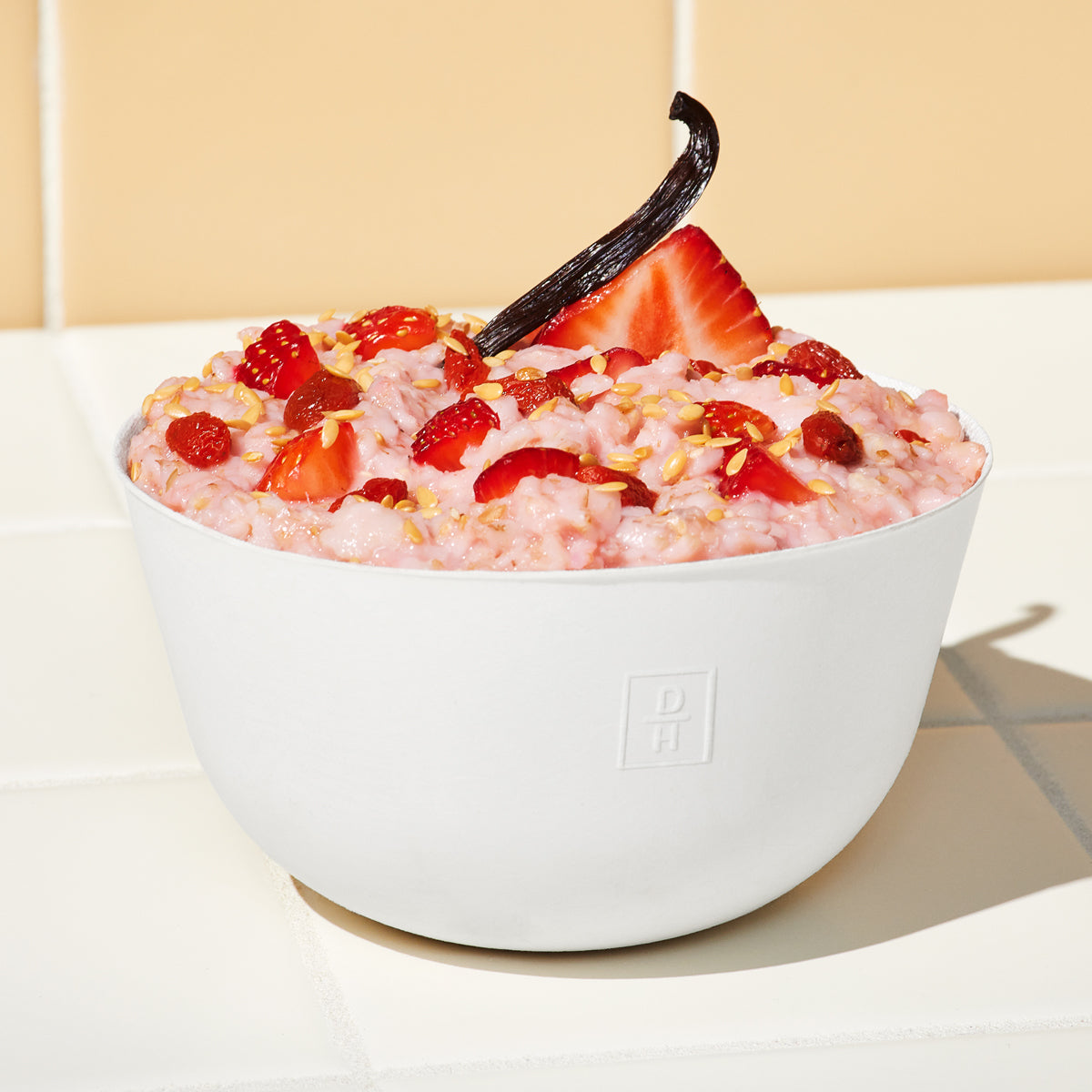 Lifestyle image of Daily Harvest Strawberry + Goji Berry Oat Bowl prepared in a bowl with a strawberry garnish.