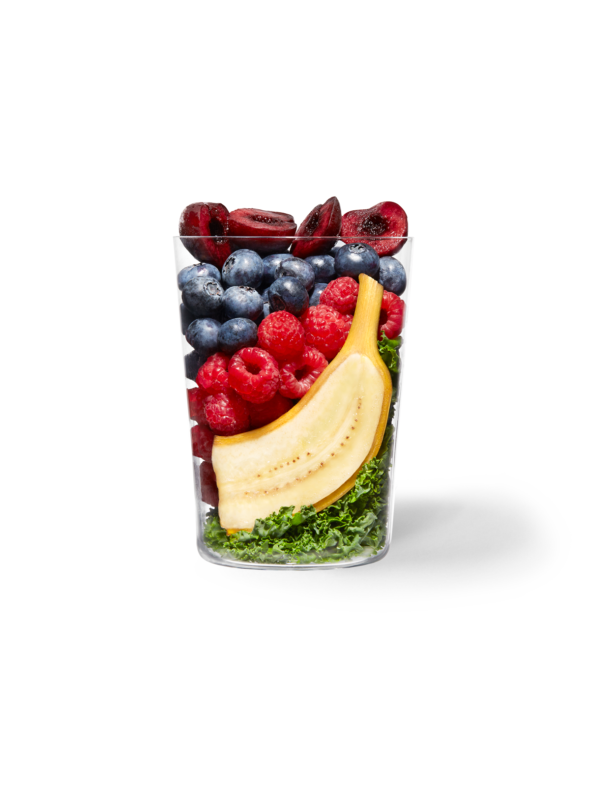 A clear cup filled with the ingredients included in our Daily Harvest Acai + Cherry Smoothie.