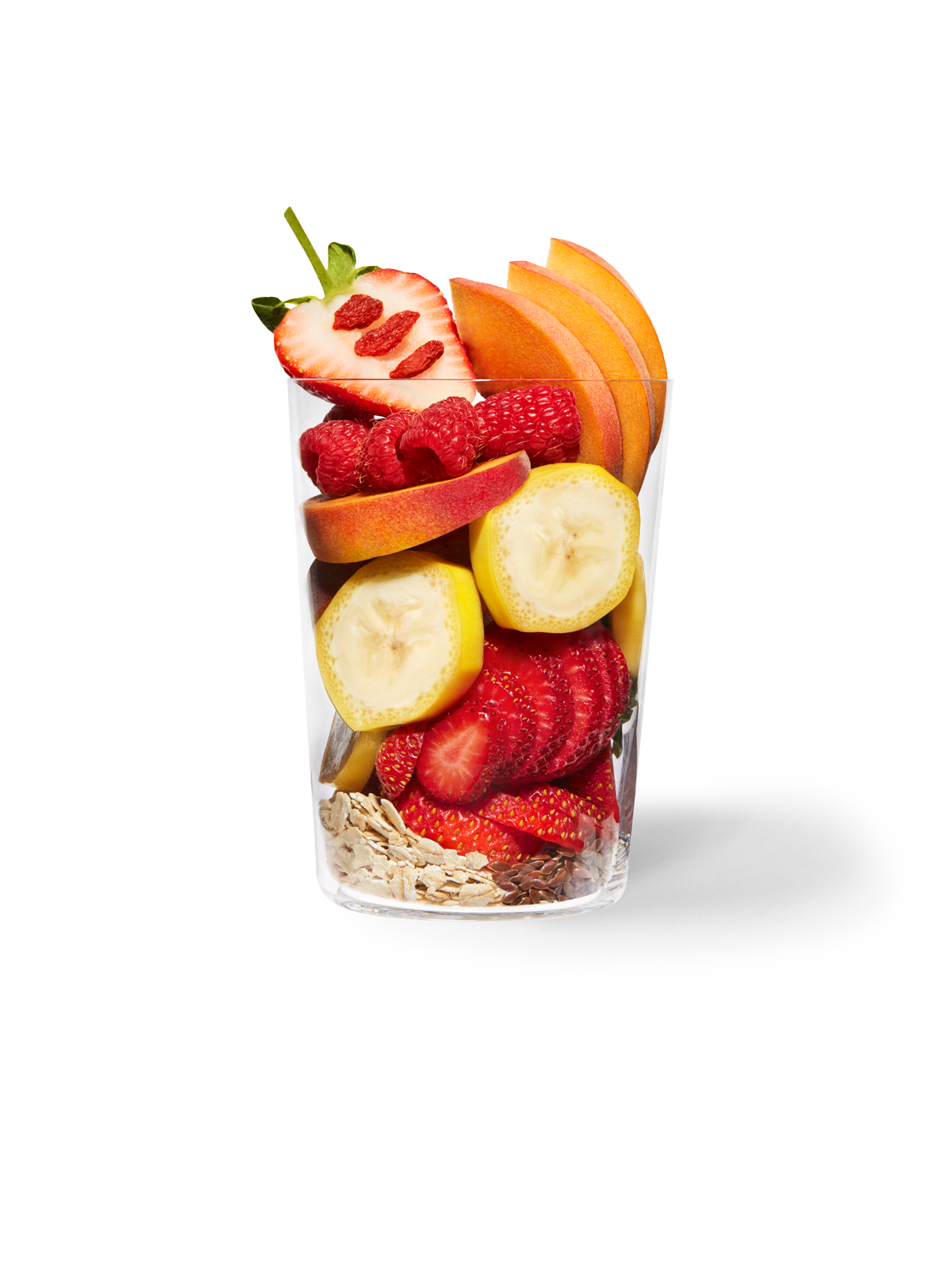 Clear cup filled with the ingredients included in our Daily Harvest Strawberry + Peach Smoothie.