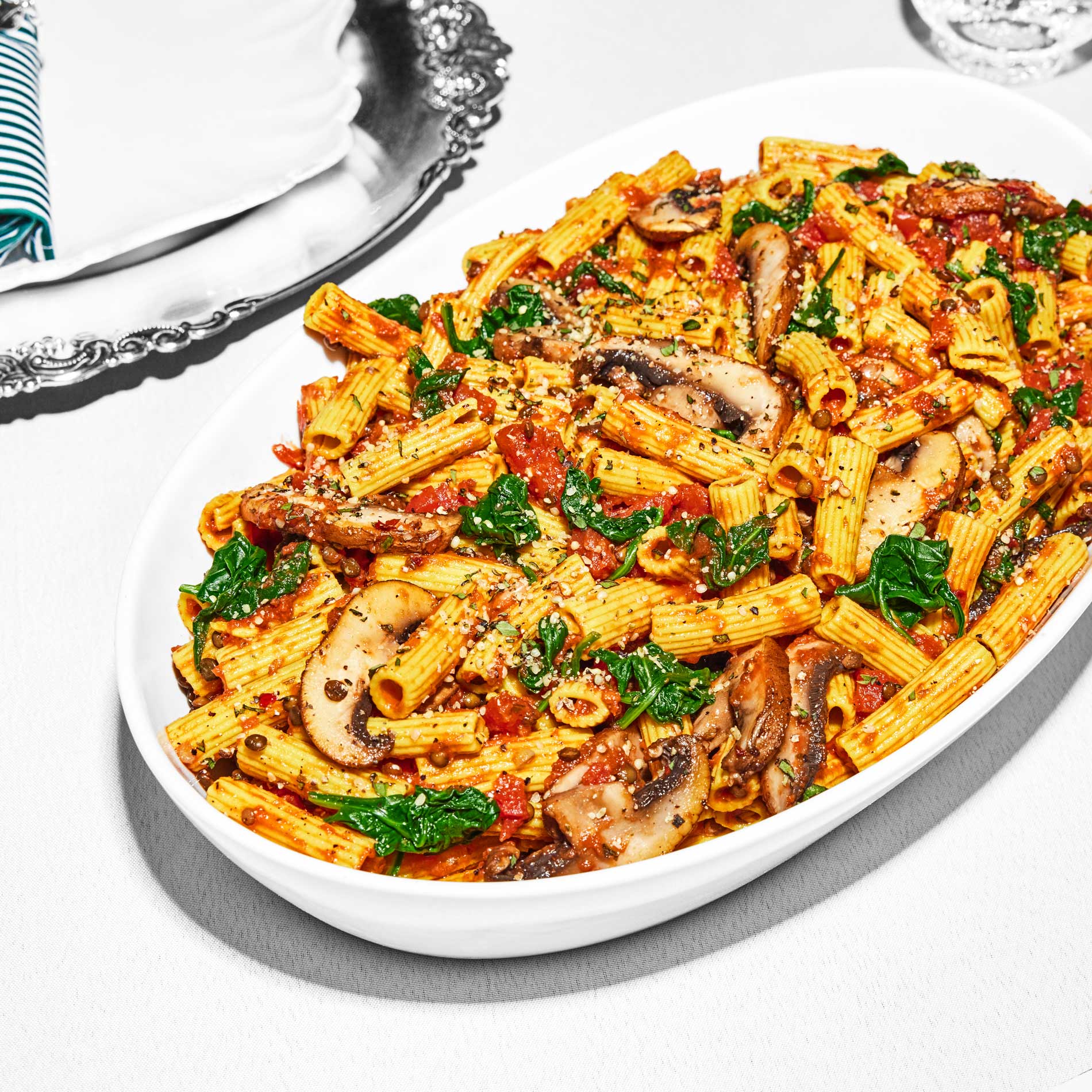 The Daily Harvest’s Tomato Basil + Portobello Bolognese Pasta on a serving bowl on a set table.