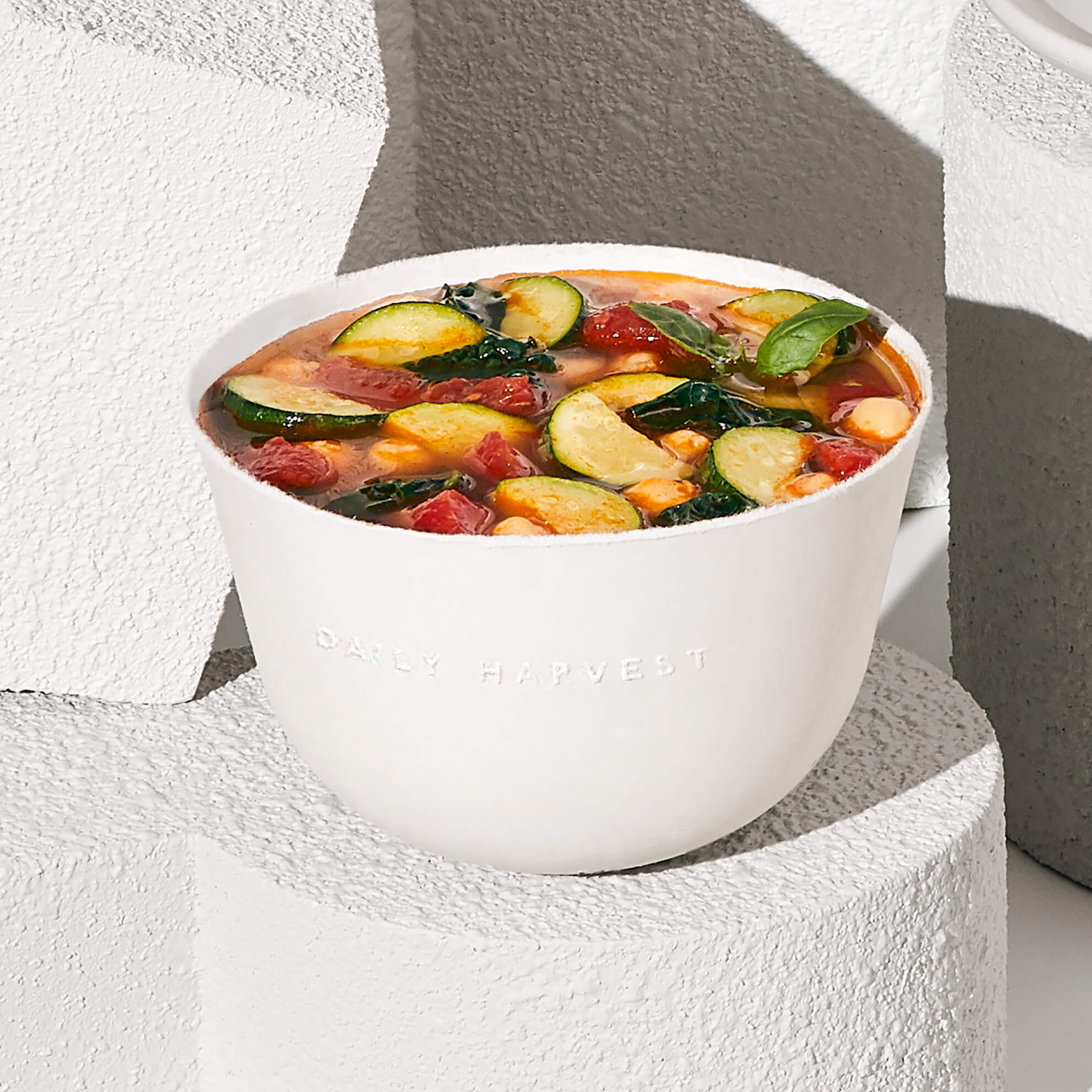 Image of Daily Harvest Tomato + Zucchini Minestrone Soup prepared in a bowl.