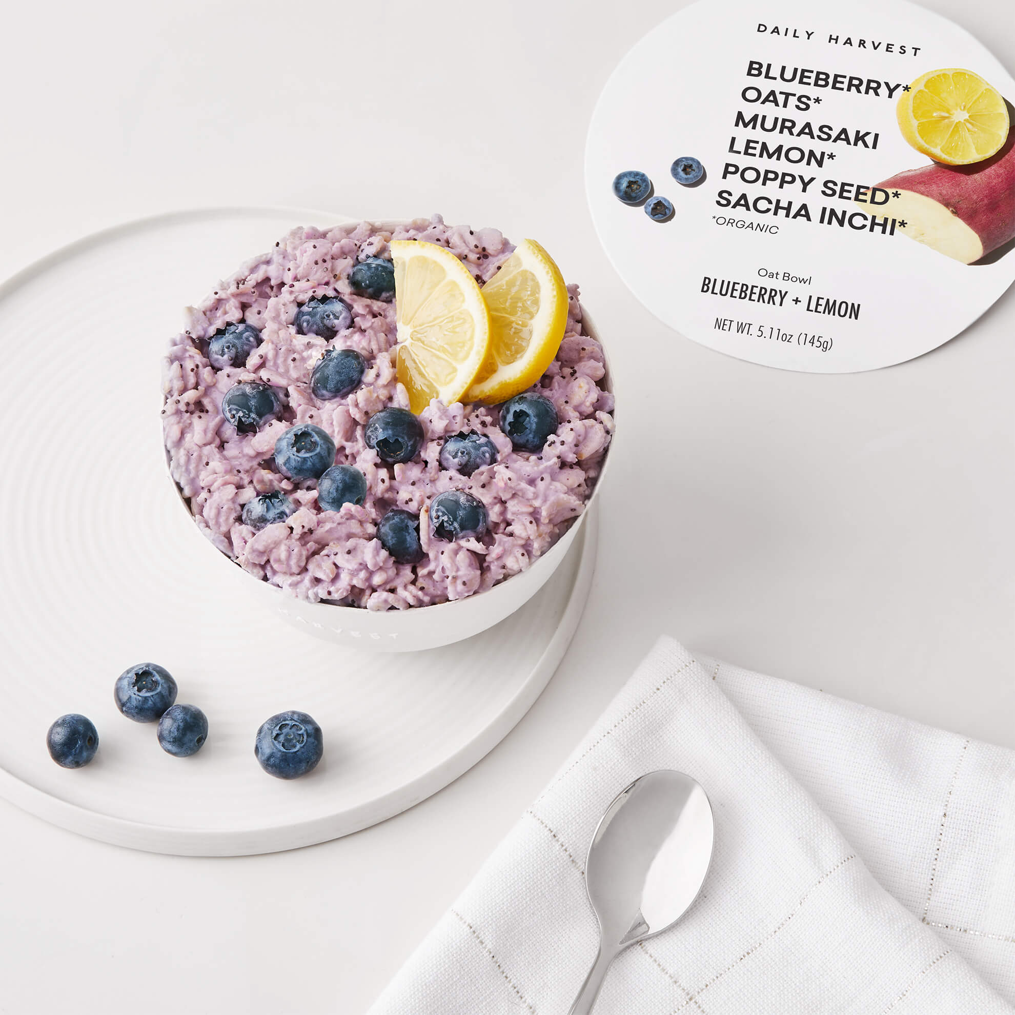 A lifestyle image of Daily Harvest Blueberry + Lemon Oat Bowl prepared with a lemon garnish.