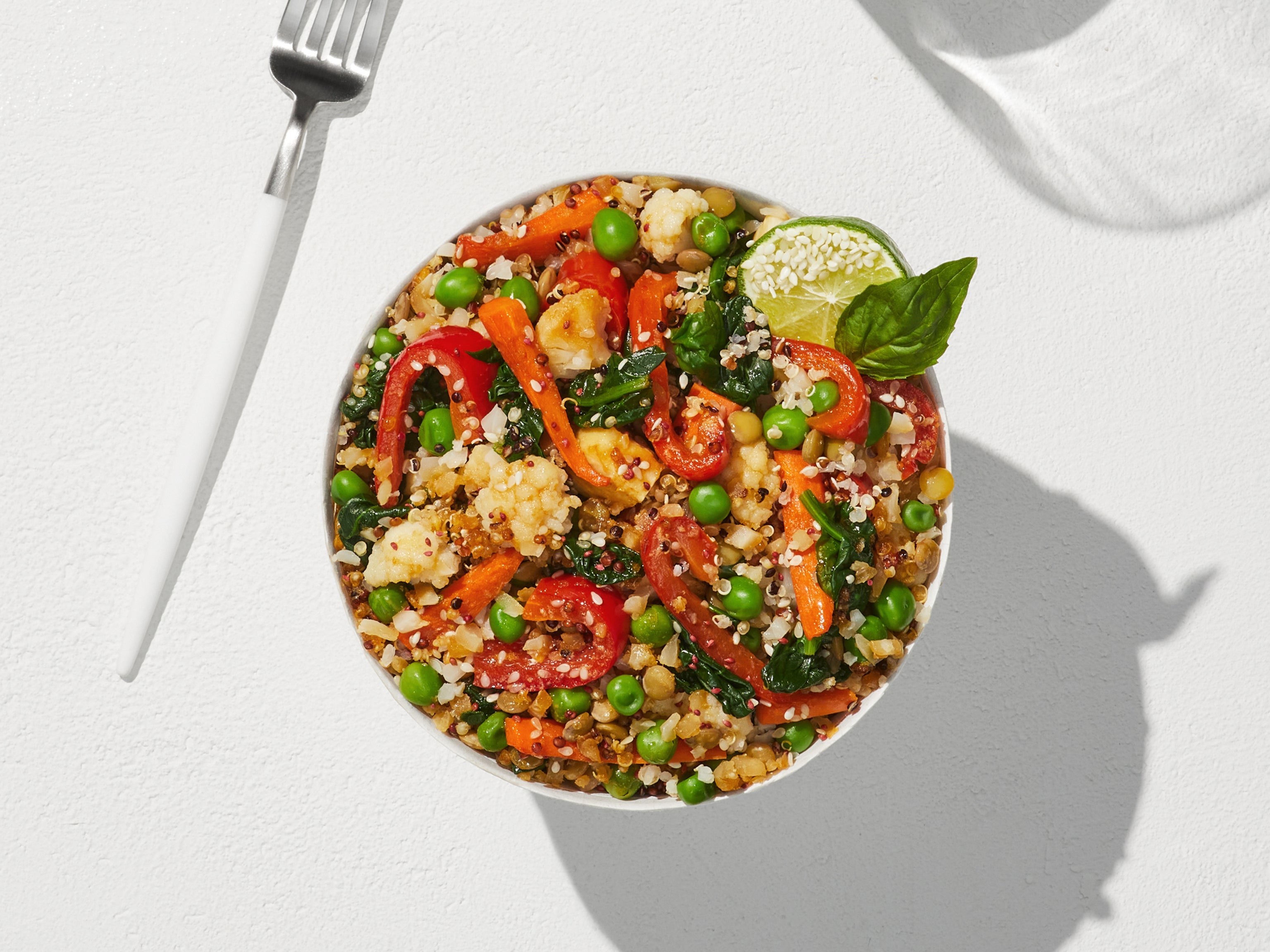 An overhead view of a prepared Quinoa + Makrut Lime Harvest Bake in a large white bowl. 