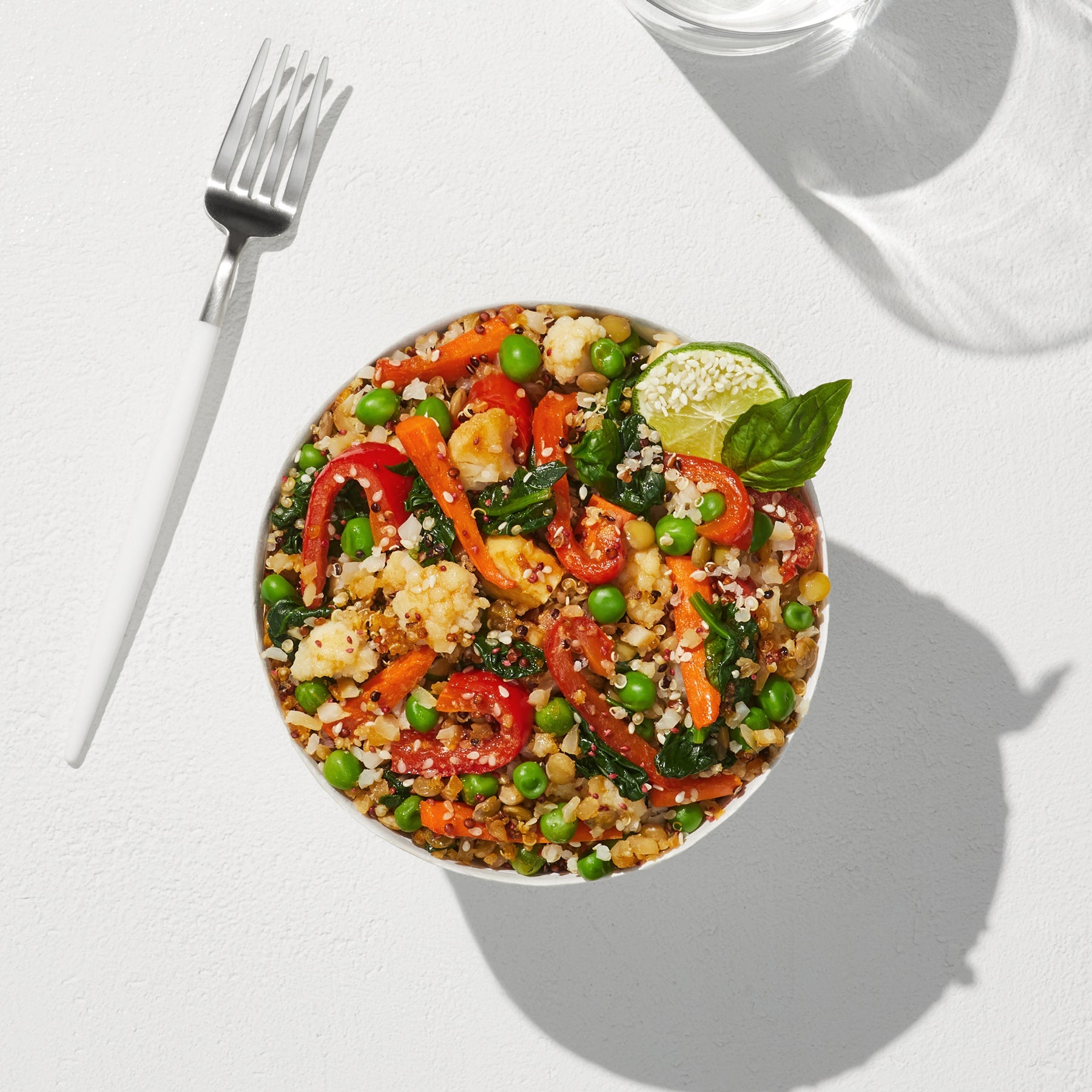 An overhead view of a prepared Quinoa + Makrut Lime Harvest Bake in a large white bowl. 
