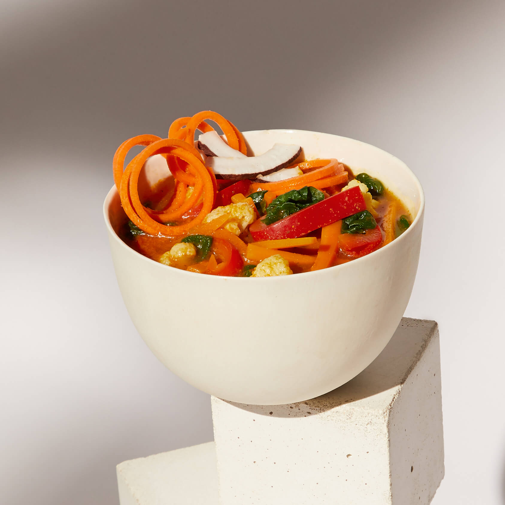 Image of a prepared Daily Harvest Carrot + Coconut Soup in a bowl with garnish.