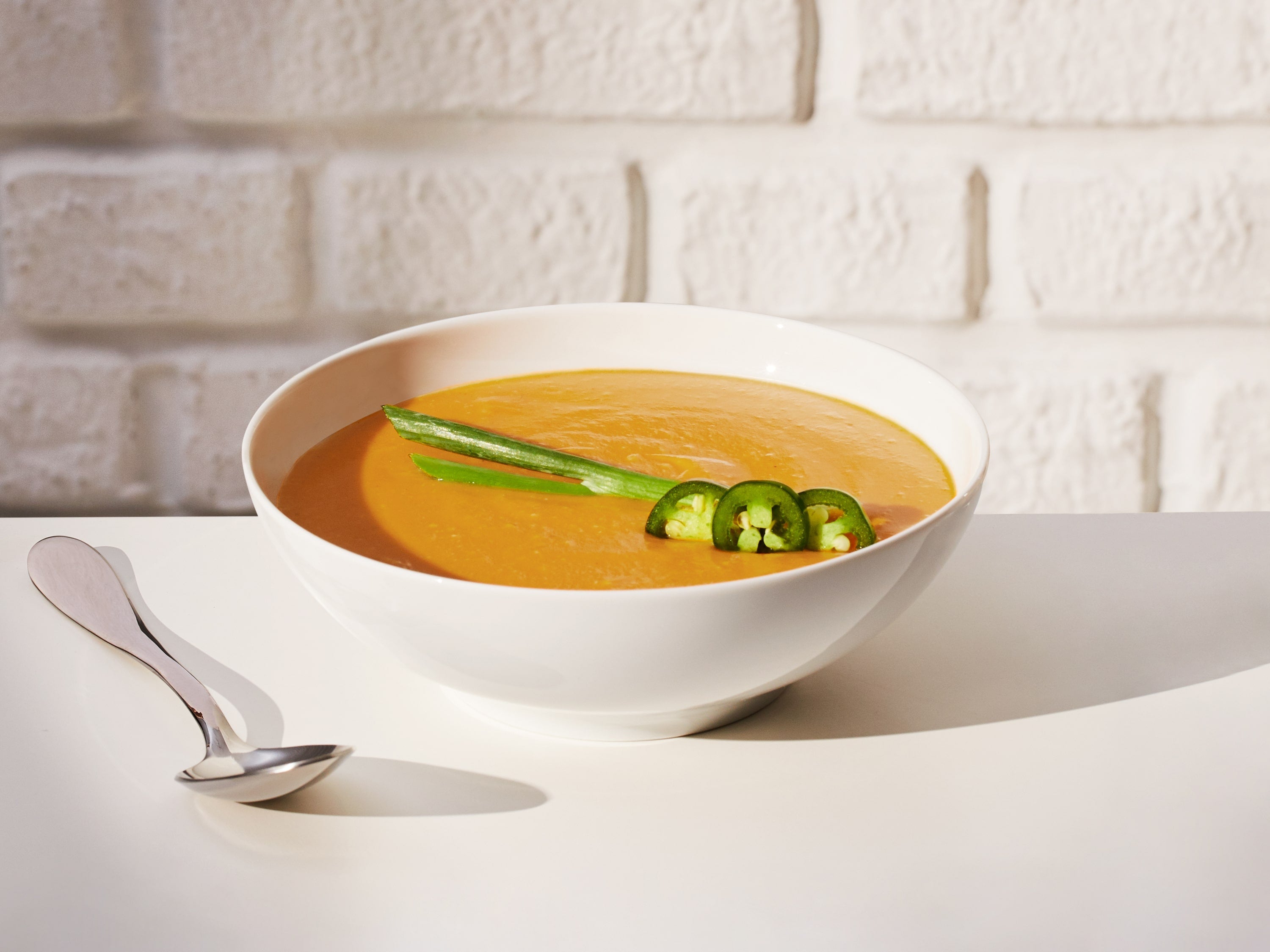 Lifestyle image of a prepared Daily Harvest Sweet Potato + Miso Soup with added garnish.