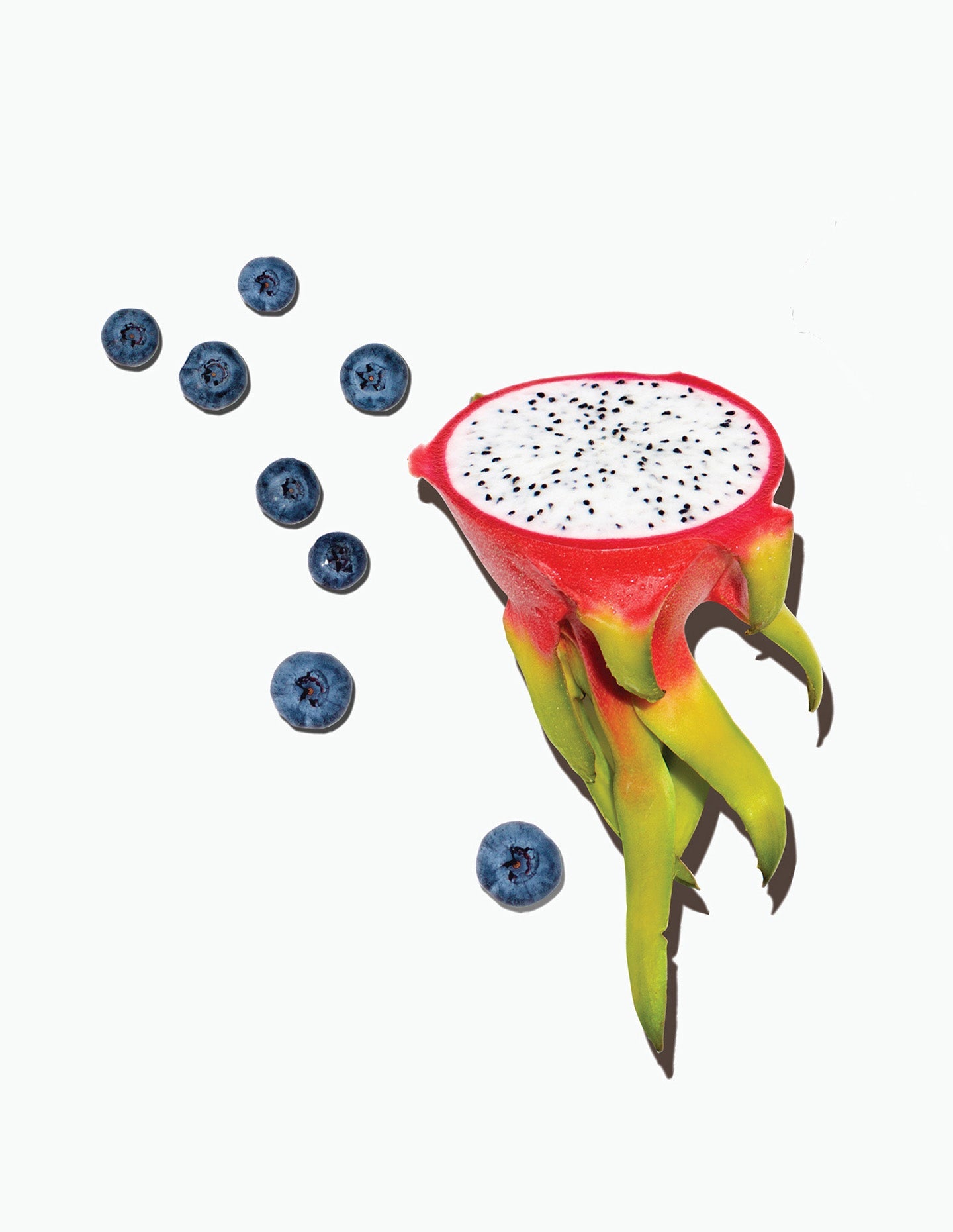 Image of Daily Harvest's Mulberry + Dragon Fruit Oat Bowl ingredients including, a sliced dragon fruit alongside a bunch of blueberries.