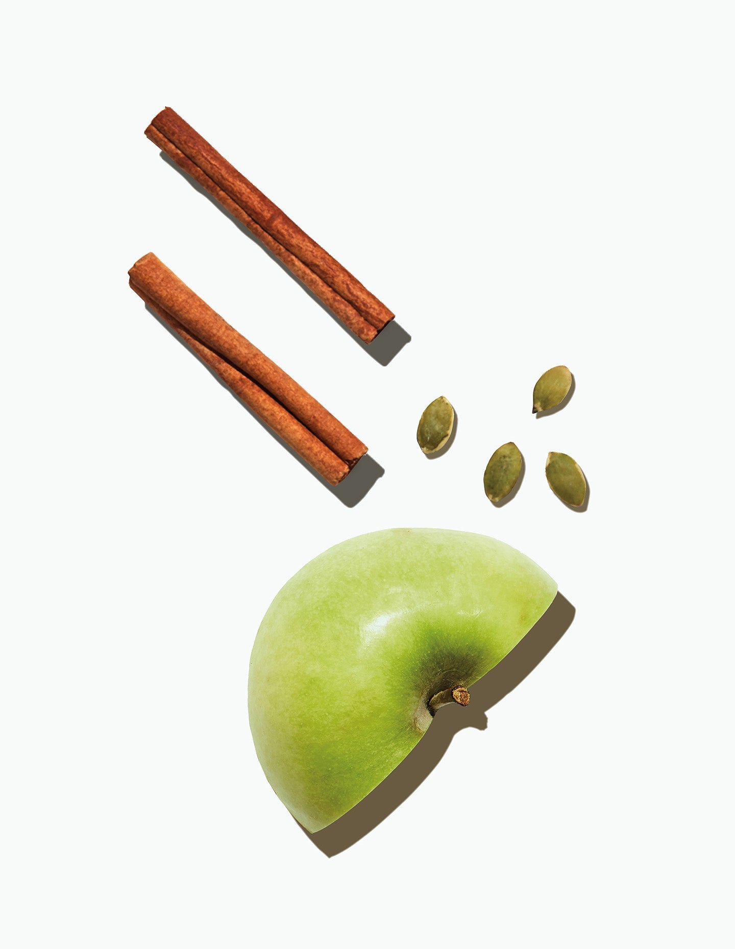 Image of Image of Daily Harvest Apple + Cinnamon Oat Bowl main ingredients, including cinnamon sticks, pumpkin seeds, and a halved apple.