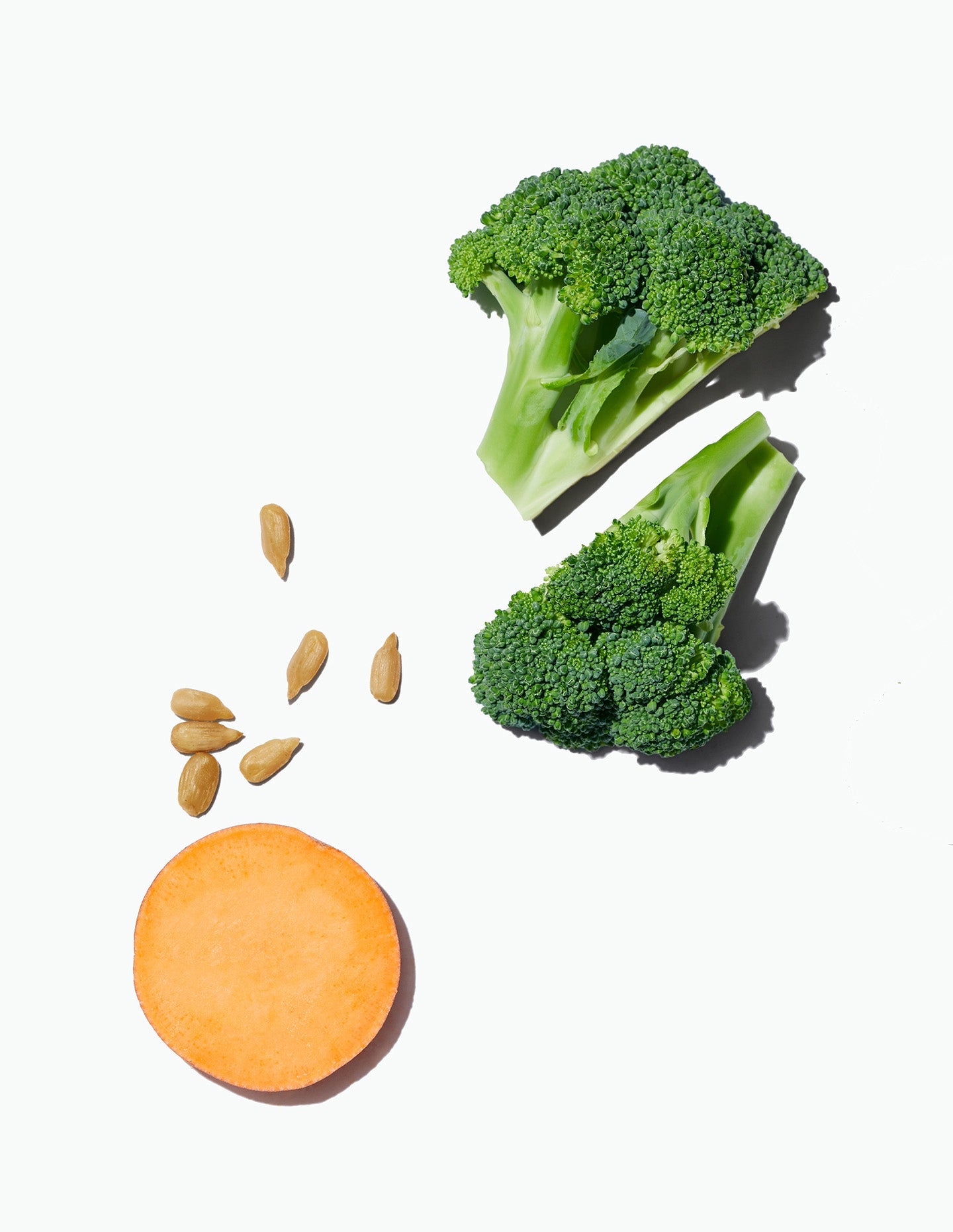 A slice of sweet potato, two broccoli pieces, and sunflower seeds