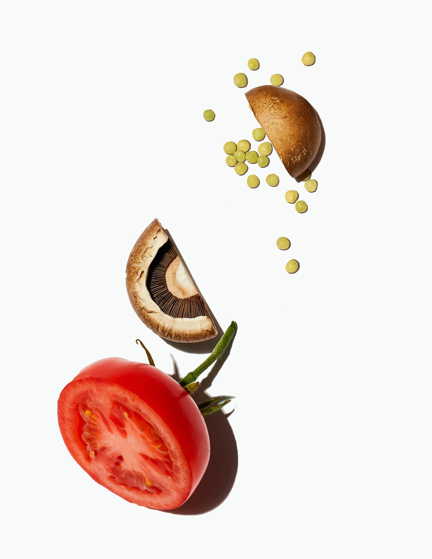 A halved tomato, sliced mushrooms, and green lentils