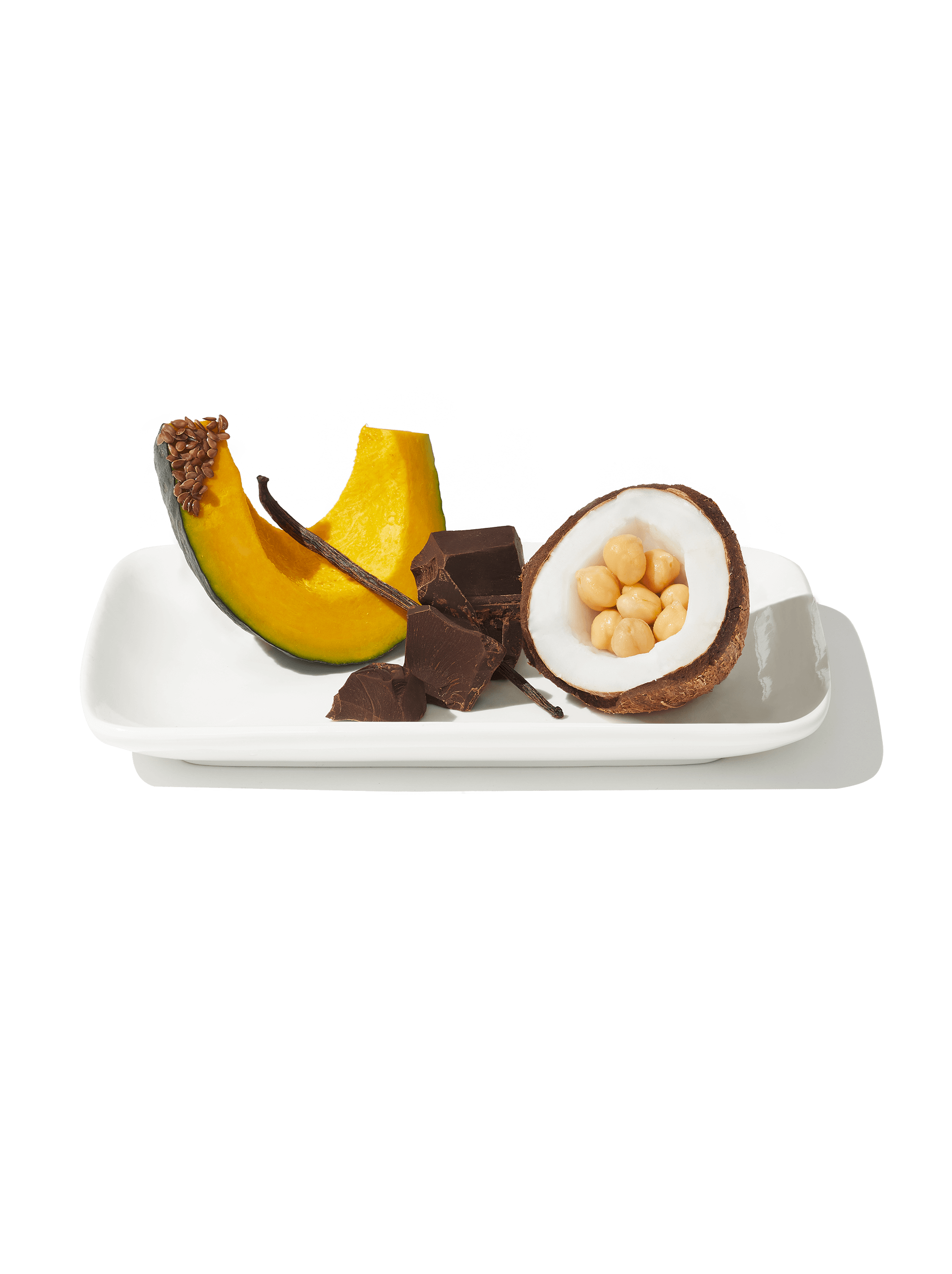 Image of Daily Harvest Cacao Nib + Vanilla bite ingredients including pumpkin, coconut, chickpeas and cacao on a plate.