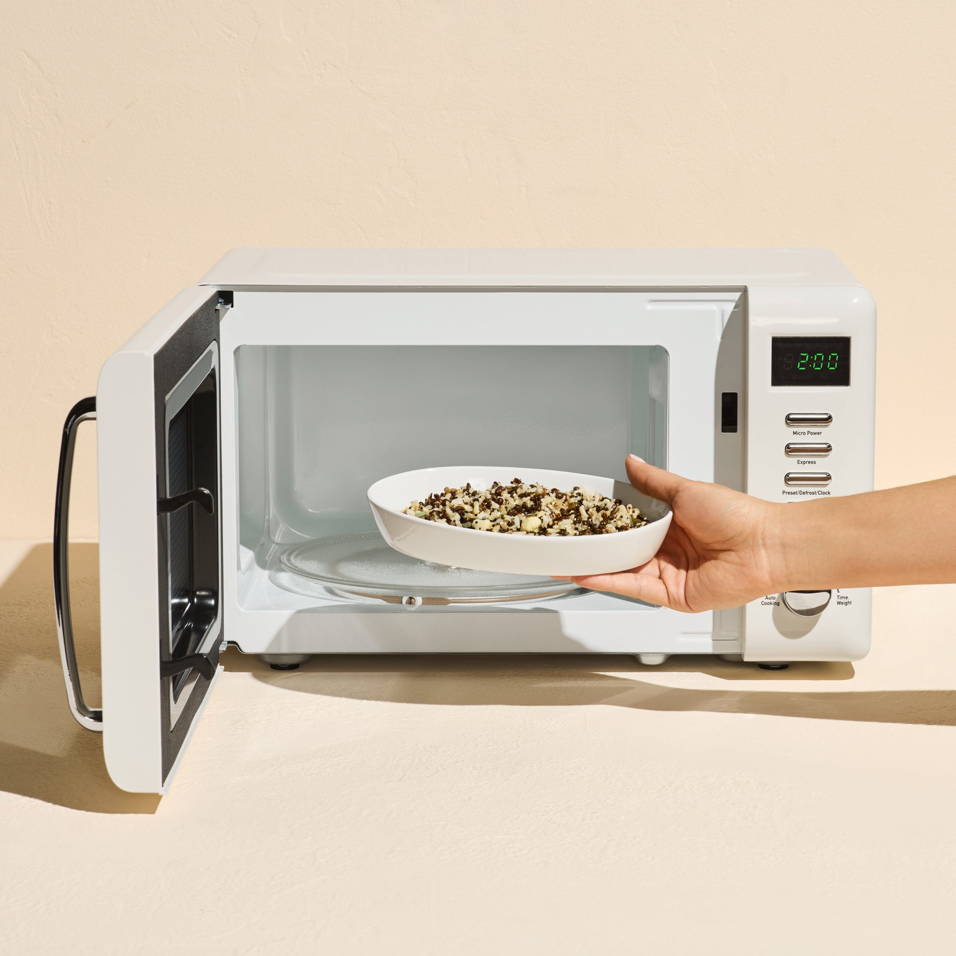 A picture of a person placing the grains in their microwave in a bowl.