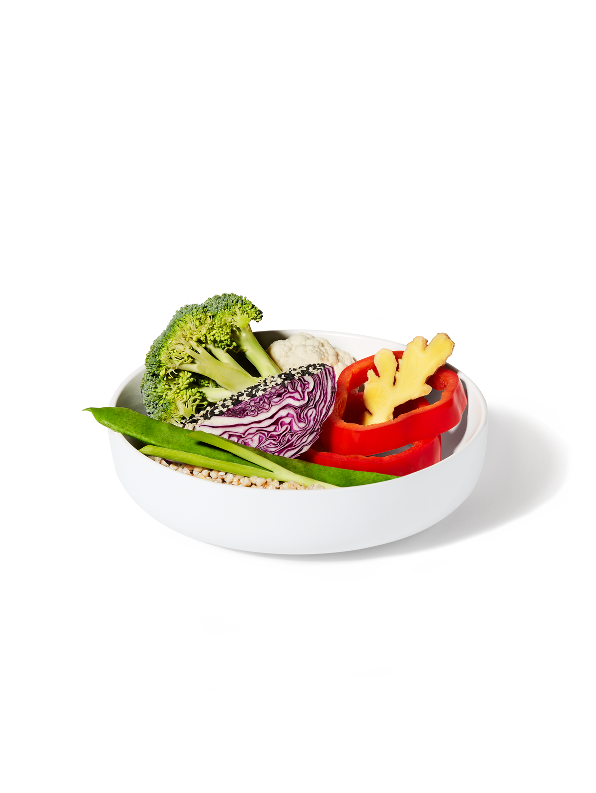 The ingredients included in Daily Harvest's Broccoli + Tamari Sesame Harvest Bowl including green onion, red cabbage, broccoli, red bell pepper, and cauliflower rice in a bowl.