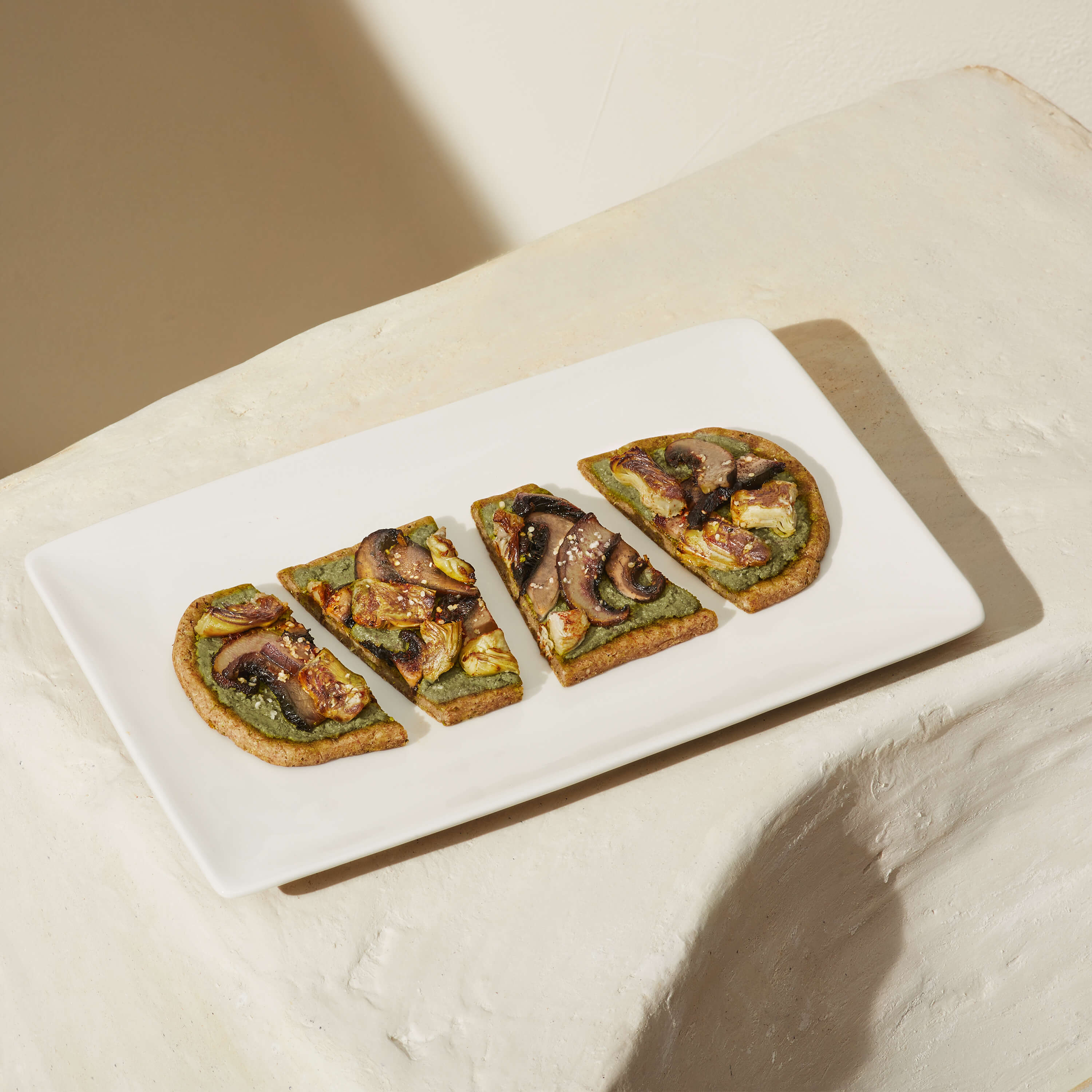 Image of prepared Daily Harvest Portobello + Pesto Flatbread on white plate